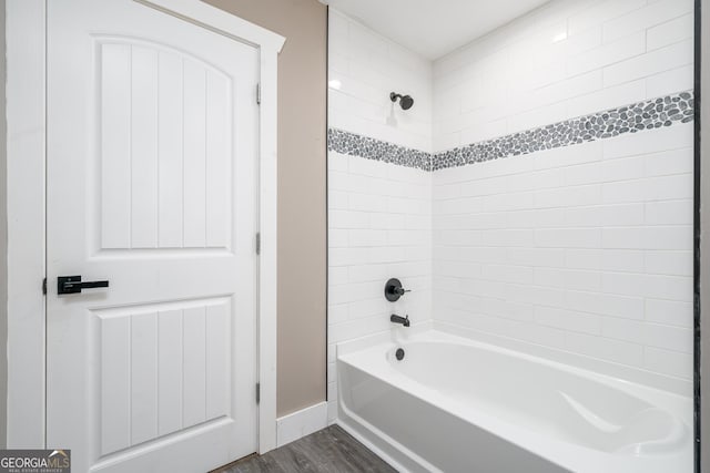 bathroom featuring wood-type flooring and tiled shower / bath