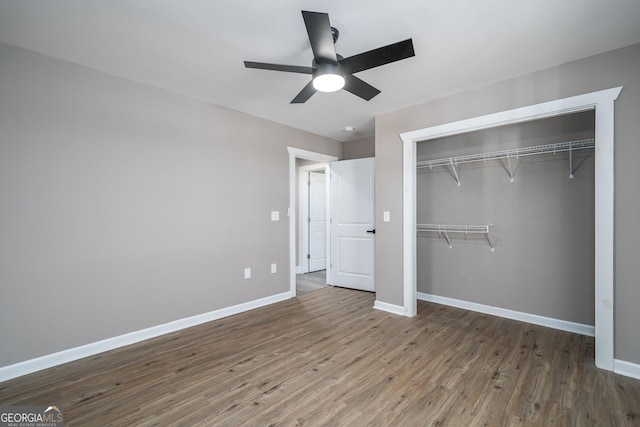 unfurnished bedroom with baseboards, a closet, wood finished floors, and a ceiling fan