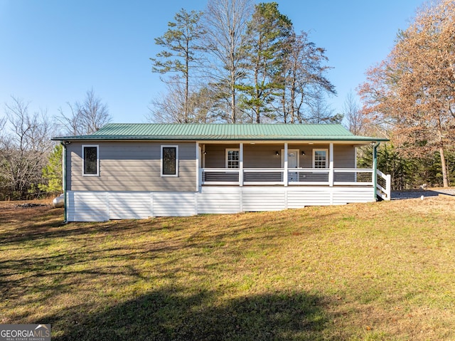 view of front facade with a front yard, a porch, and metal roof