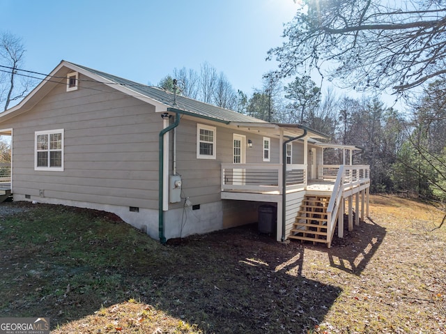 rear view of property featuring crawl space, metal roof, stairs, and a deck