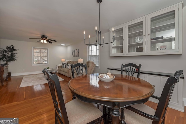 dining room featuring wood-type flooring and ceiling fan with notable chandelier