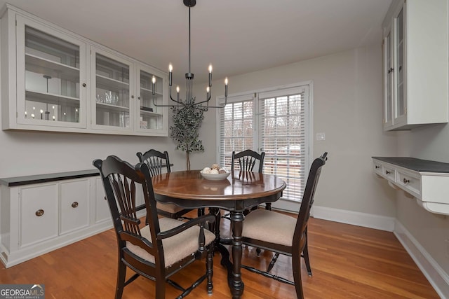 dining area with an inviting chandelier and light hardwood / wood-style flooring