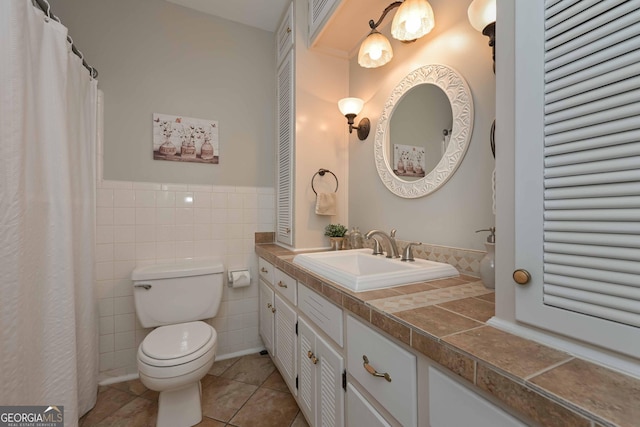 bathroom with tile patterned flooring, vanity, tile walls, and toilet