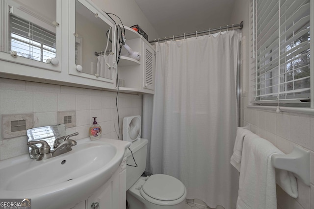 bathroom featuring vanity, tasteful backsplash, toilet, and tile walls