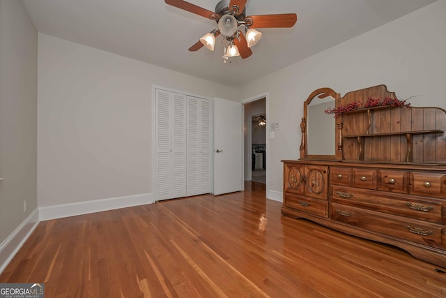 unfurnished bedroom with hardwood / wood-style floors, a closet, and ceiling fan