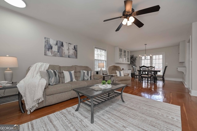 living room featuring ceiling fan with notable chandelier and light hardwood / wood-style floors