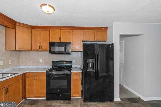 kitchen with decorative backsplash, black appliances, and a textured ceiling