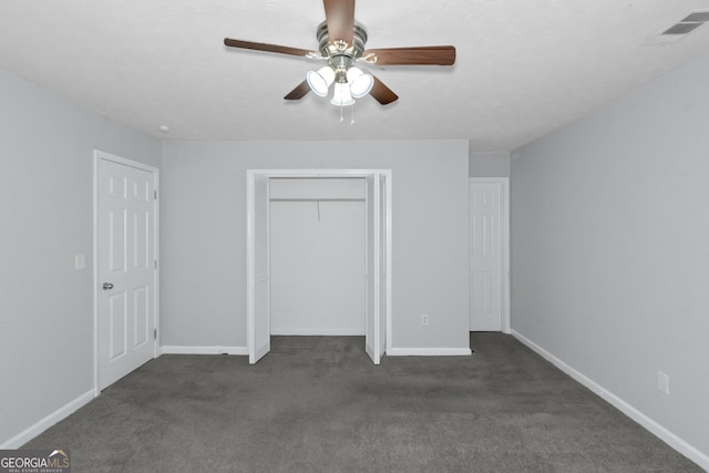 unfurnished bedroom with ceiling fan and dark colored carpet