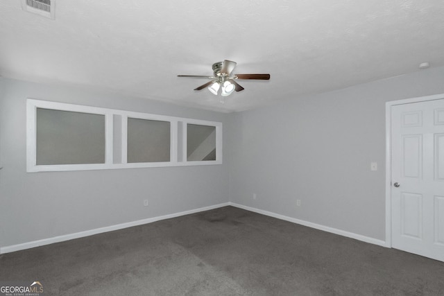 empty room with dark carpet and ceiling fan