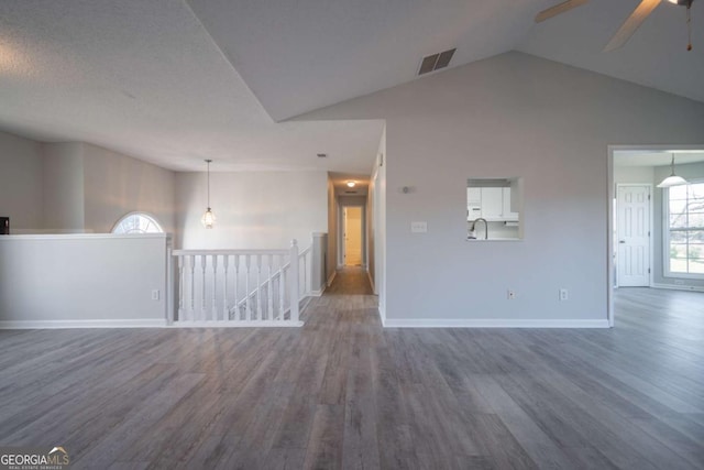 unfurnished room featuring ceiling fan, wood-type flooring, a textured ceiling, and high vaulted ceiling