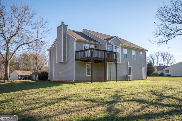 rear view of house featuring a lawn and a deck