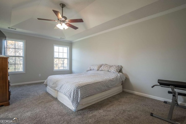 bedroom with a raised ceiling, ceiling fan, carpet flooring, and crown molding