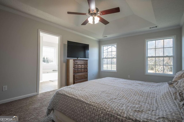 carpeted bedroom with a tray ceiling, ceiling fan, and crown molding