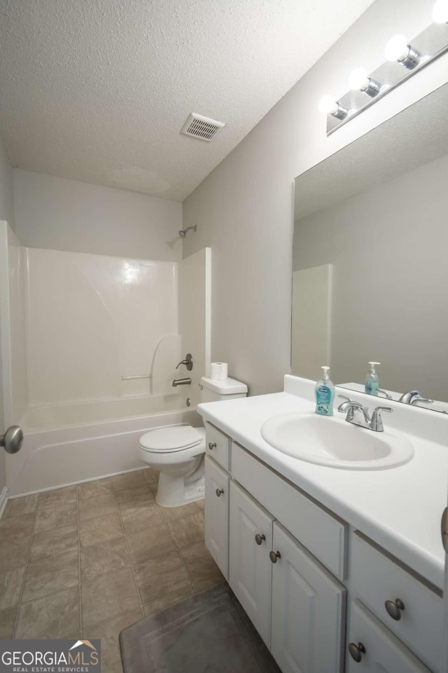 full bathroom with tile patterned flooring, a textured ceiling, toilet, shower / tub combination, and vanity