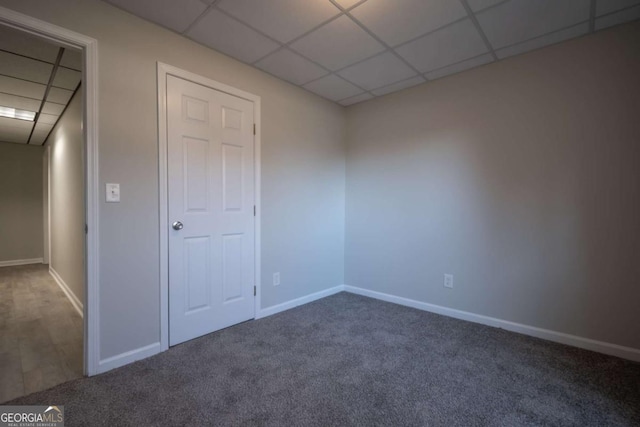 unfurnished bedroom with carpet flooring and a paneled ceiling