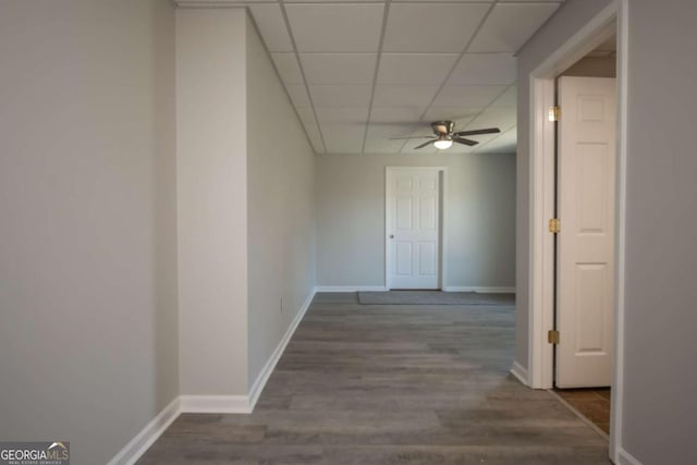 hall with hardwood / wood-style flooring and a paneled ceiling