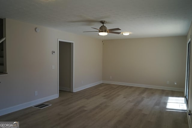 unfurnished room with ceiling fan, hardwood / wood-style floors, and a textured ceiling