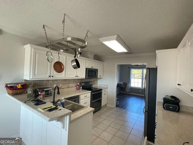 kitchen with double oven range, stainless steel fridge, kitchen peninsula, and white cabinets