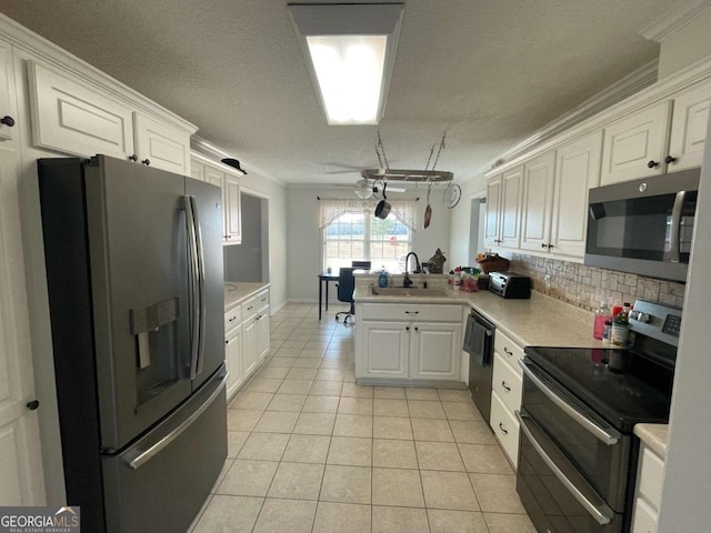 kitchen featuring sink, light tile patterned floors, appliances with stainless steel finishes, white cabinetry, and kitchen peninsula