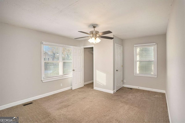 unfurnished bedroom with carpet flooring, a textured ceiling, and ceiling fan