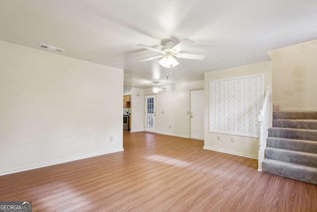 unfurnished living room featuring ceiling fan and light hardwood / wood-style flooring