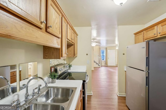 kitchen featuring ceiling fan, light hardwood / wood-style floors, sink, and appliances with stainless steel finishes