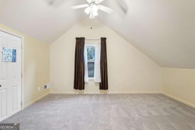 additional living space featuring ceiling fan, light colored carpet, and vaulted ceiling