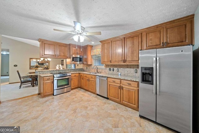 kitchen featuring appliances with stainless steel finishes, backsplash, a textured ceiling, ceiling fan, and sink