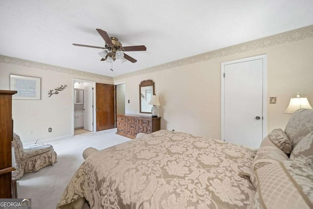 bedroom featuring ceiling fan, light carpet, and ensuite bath