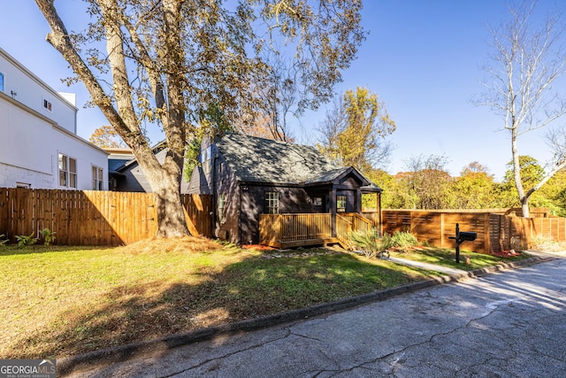 view of side of home featuring a wooden deck and a yard