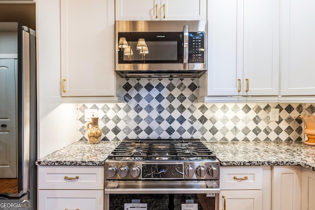 kitchen featuring light stone countertops, backsplash, and appliances with stainless steel finishes