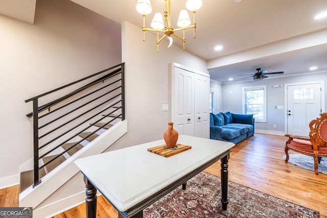 dining room featuring ceiling fan with notable chandelier, hardwood / wood-style flooring, and crown molding