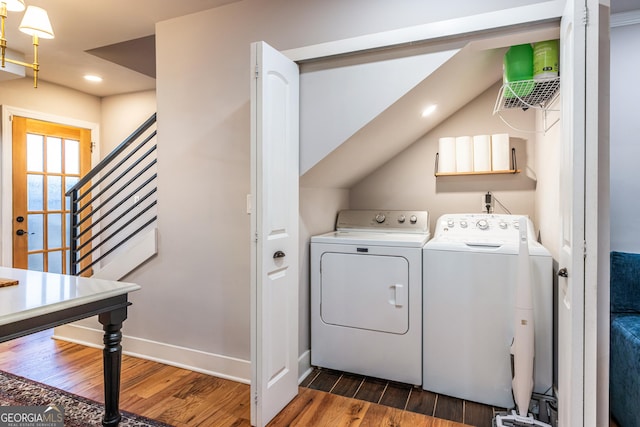 laundry room with washer and clothes dryer and dark wood-type flooring