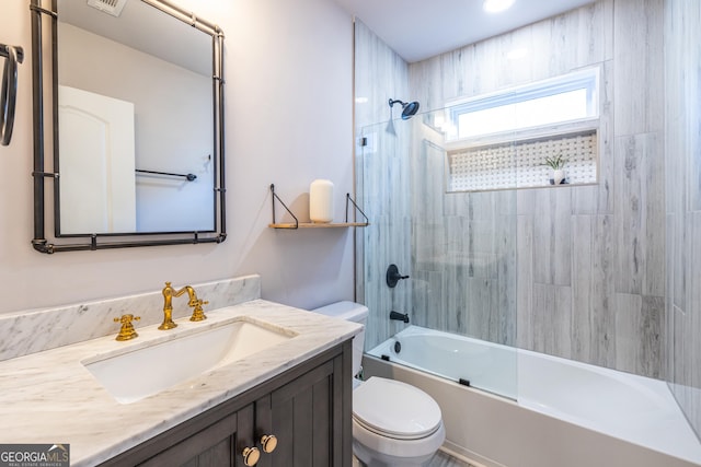 full bathroom with tiled shower / bath combo, toilet, and vanity