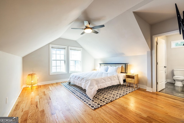 bedroom featuring hardwood / wood-style floors, connected bathroom, ceiling fan, and lofted ceiling