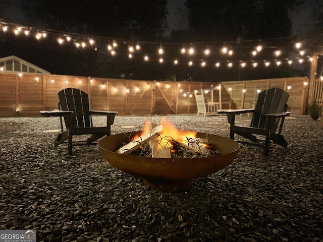 patio at night featuring an outdoor fire pit