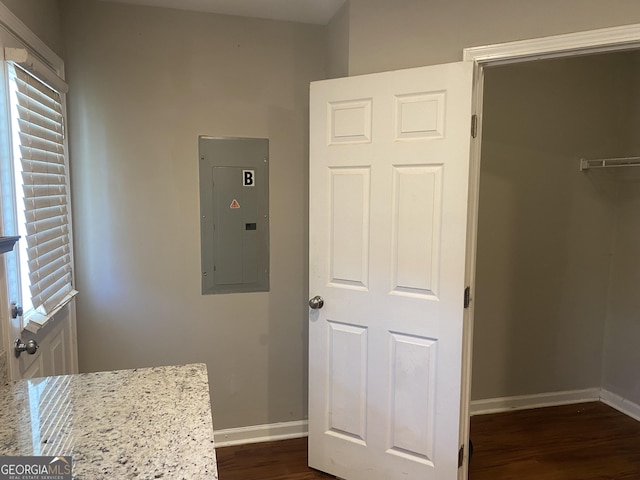 bathroom featuring wood finished floors, electric panel, and baseboards