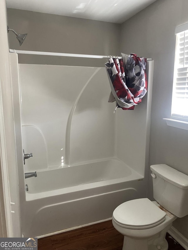 full bathroom featuring shower / tub combination, wood finished floors, and toilet