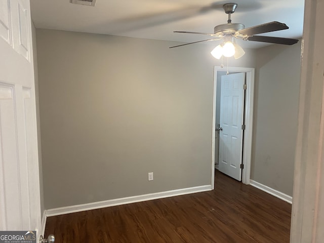 unfurnished room featuring visible vents, baseboards, and dark wood-style flooring