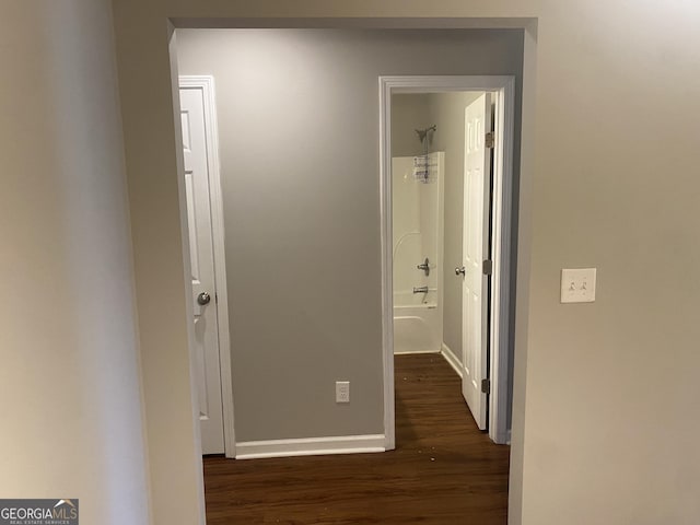 hallway featuring baseboards and dark wood finished floors