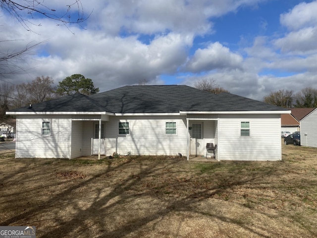 rear view of property with a lawn