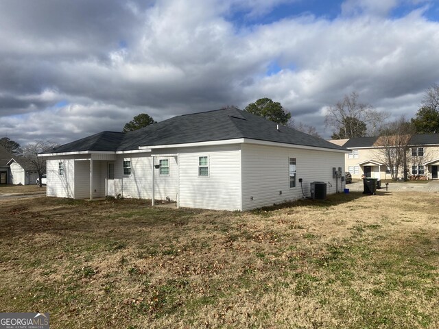 view of home's exterior featuring central air condition unit and a yard