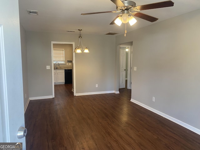 spare room featuring dark wood-style floors, baseboards, visible vents, and ceiling fan with notable chandelier