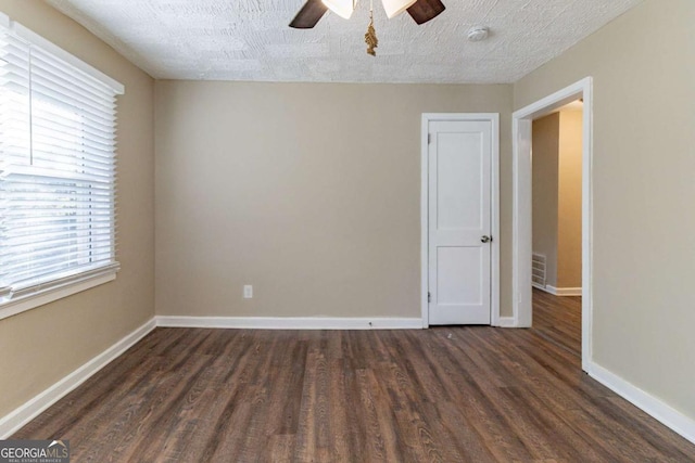 empty room featuring ceiling fan, dark hardwood / wood-style flooring, and a textured ceiling