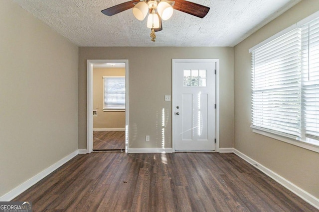 entryway with a healthy amount of sunlight, dark wood-type flooring, and a textured ceiling