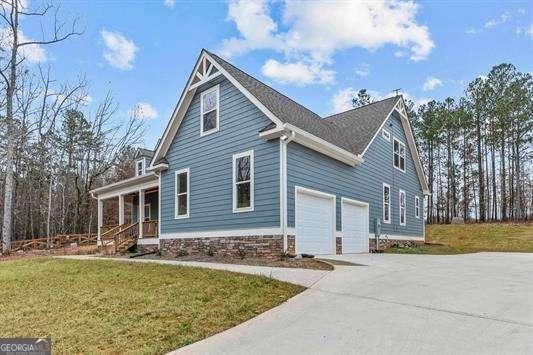 view of home's exterior with a garage, a yard, driveway, and a porch