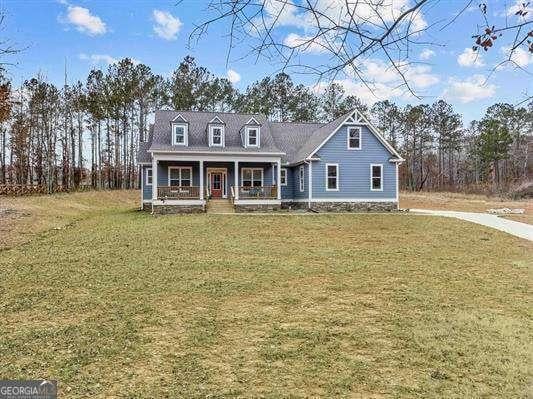 cape cod house with covered porch and a front lawn