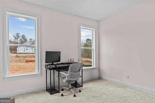 carpeted home office featuring baseboards