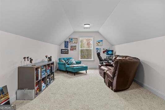 living area with lofted ceiling, carpet, and baseboards