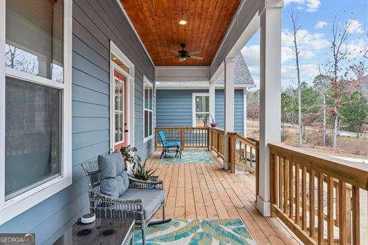 wooden deck featuring covered porch and ceiling fan